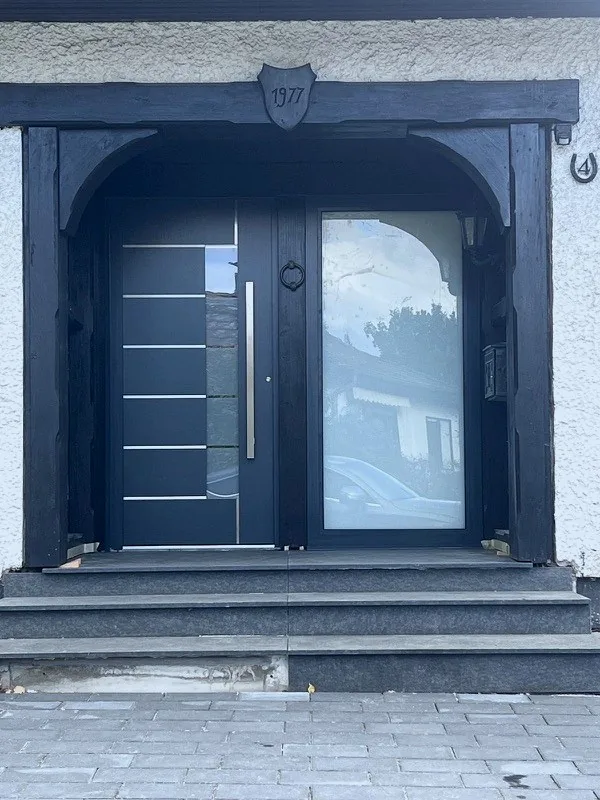 Anthrazitfarbene Haustür mit Seitenteil in historischem Türrahmen – Altbau