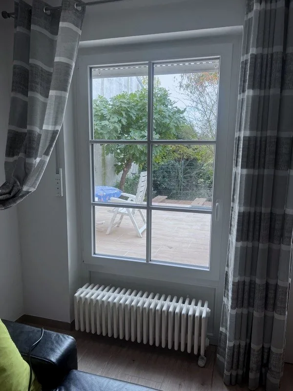Neues weißes Sprossenfenster von innen mit Blick in den Garten